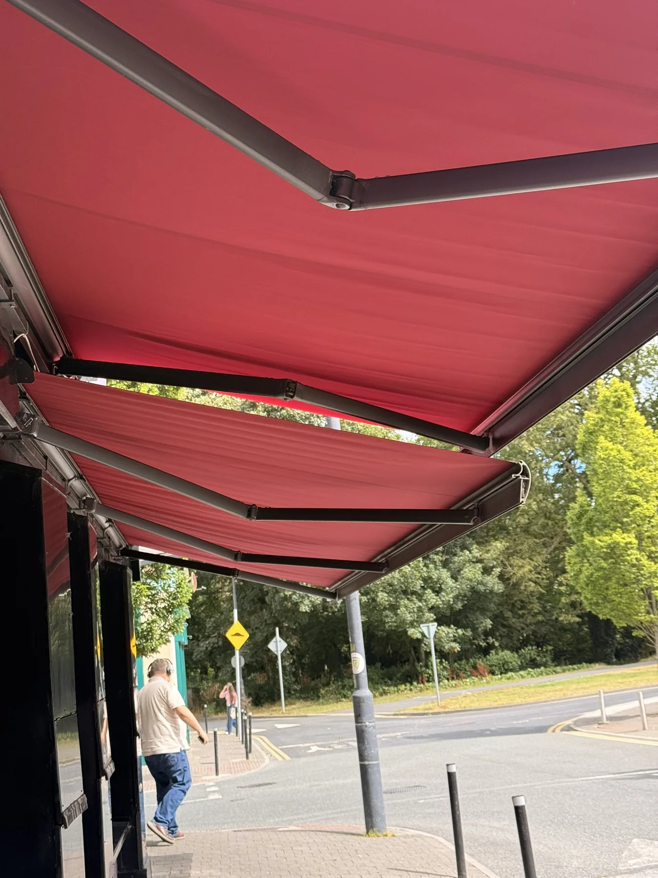 Red retractable awning viewed from underneath after fabric and repair work