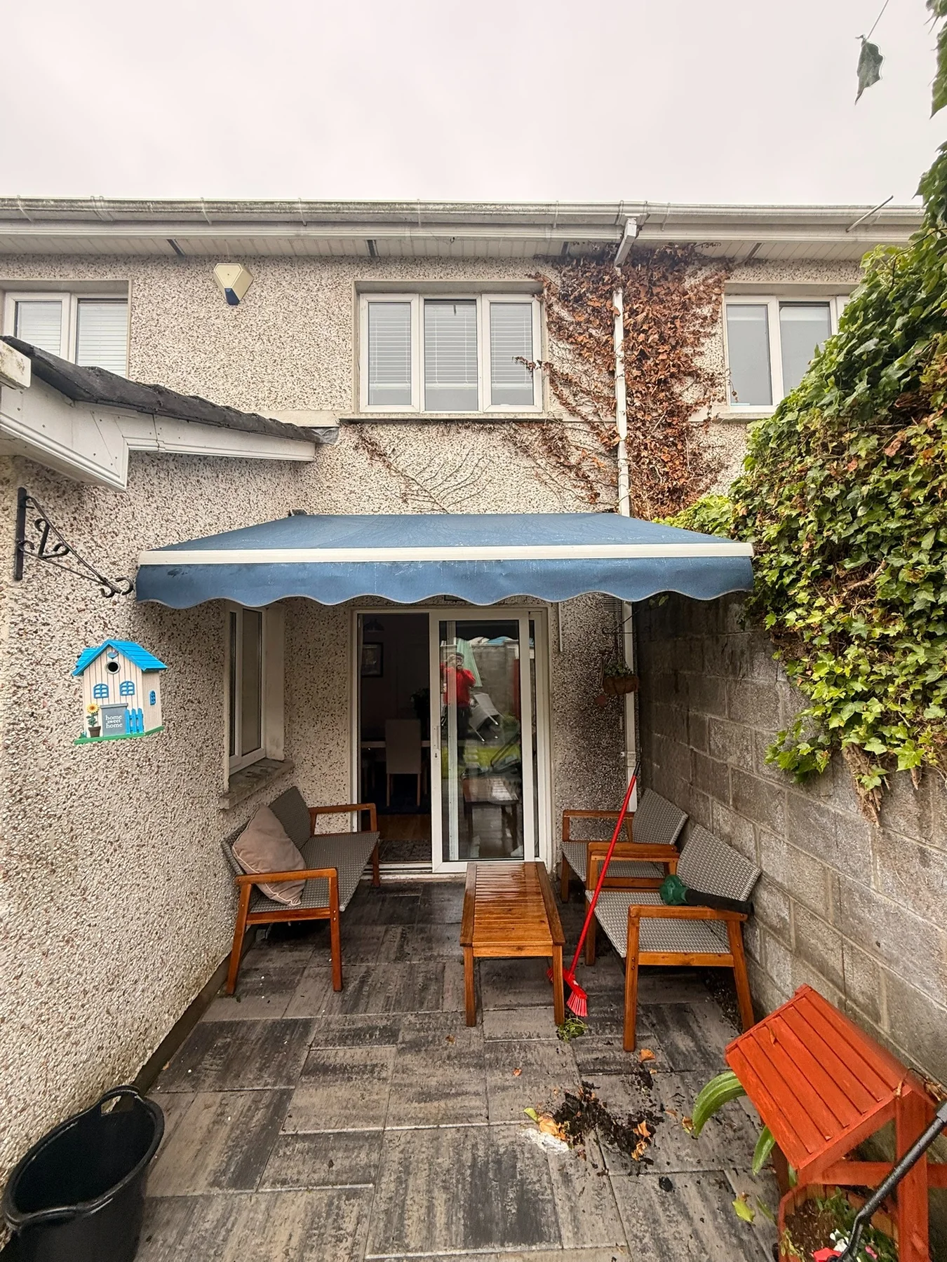 Residential patio awning with renewed dark fabric after repair work in Ireland