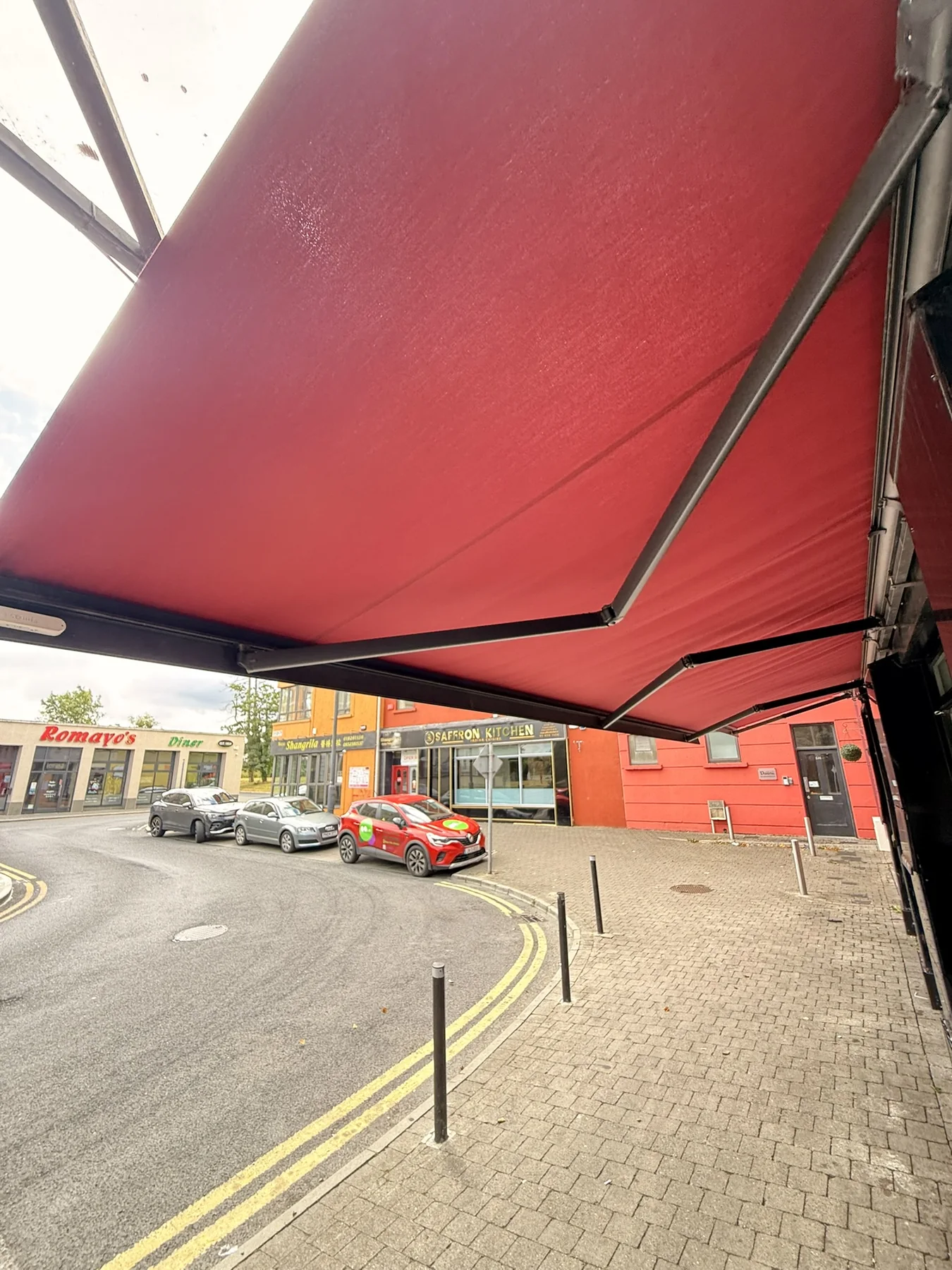 Commercial red awning viewed from the street after repair and renewed fabric