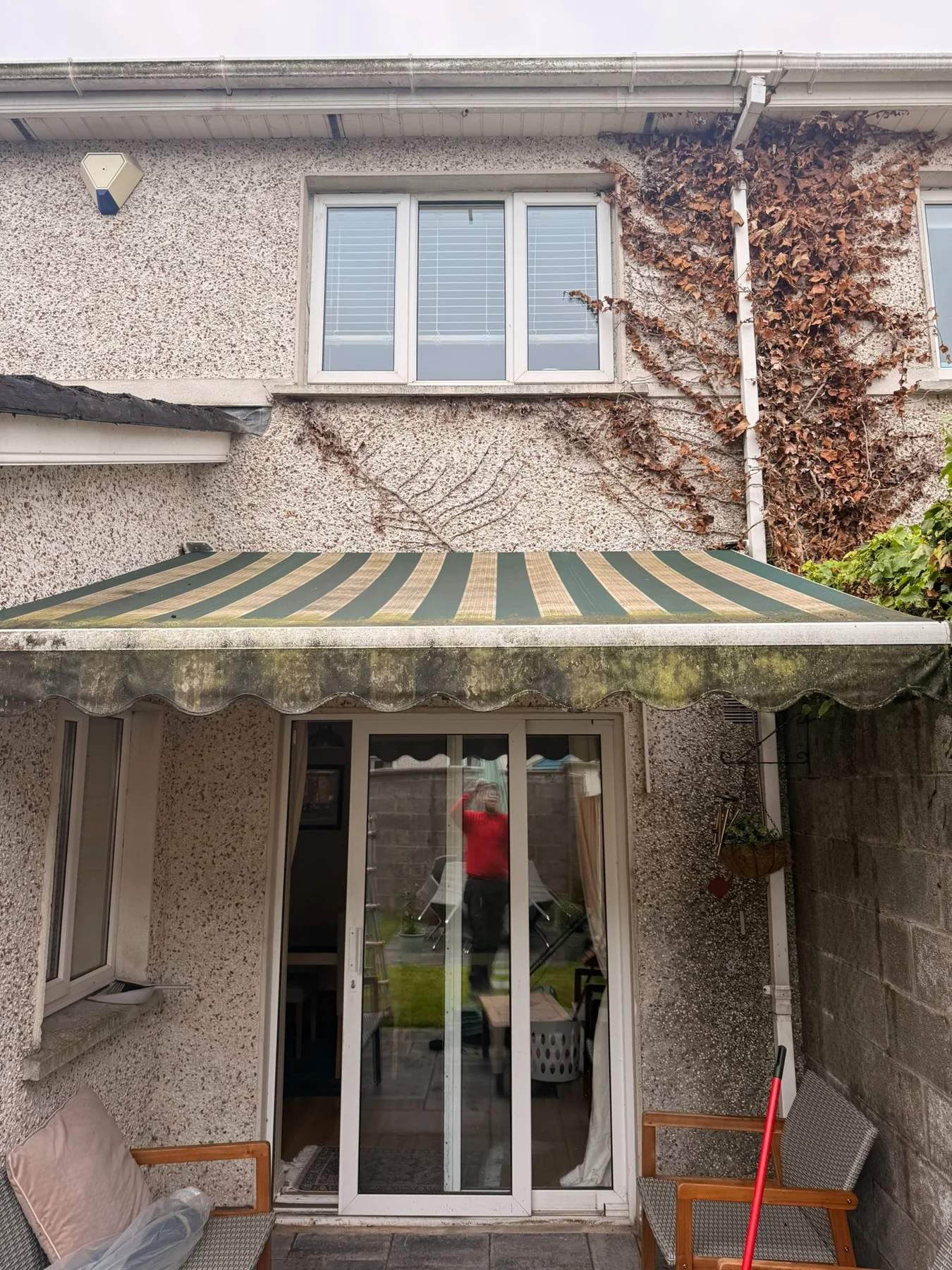 Weathered striped patio awning with staining and aged fabric on a home in Ireland
