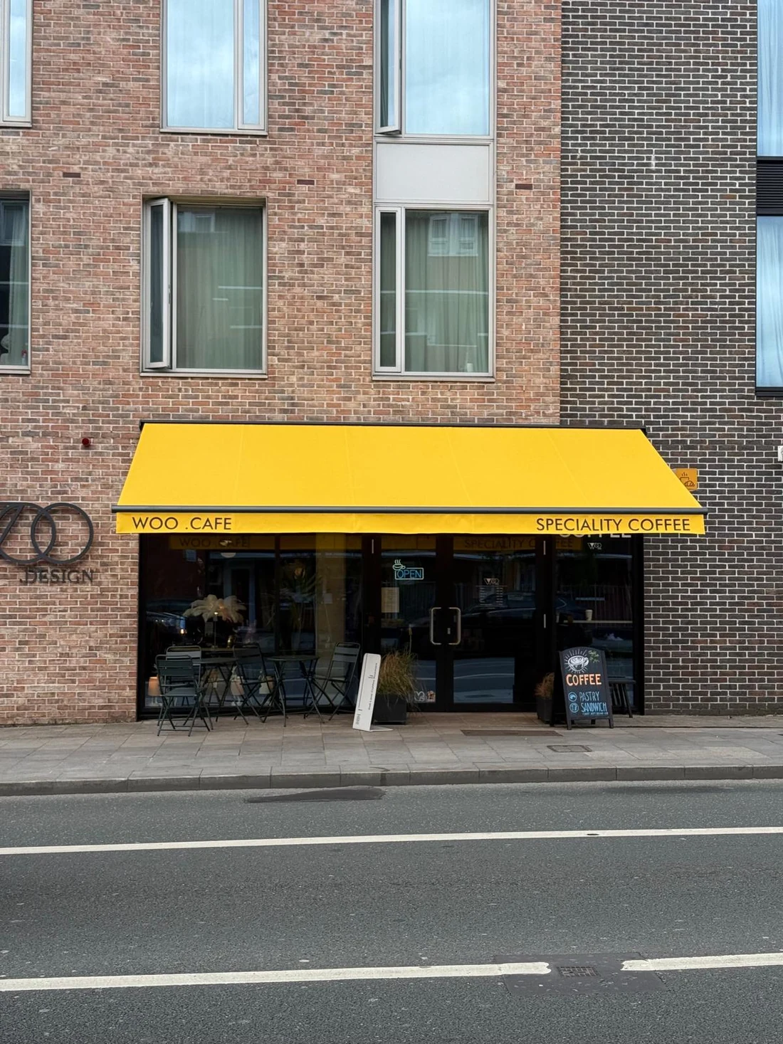 Yellow commercial awning with printed branding above a cafe frontage