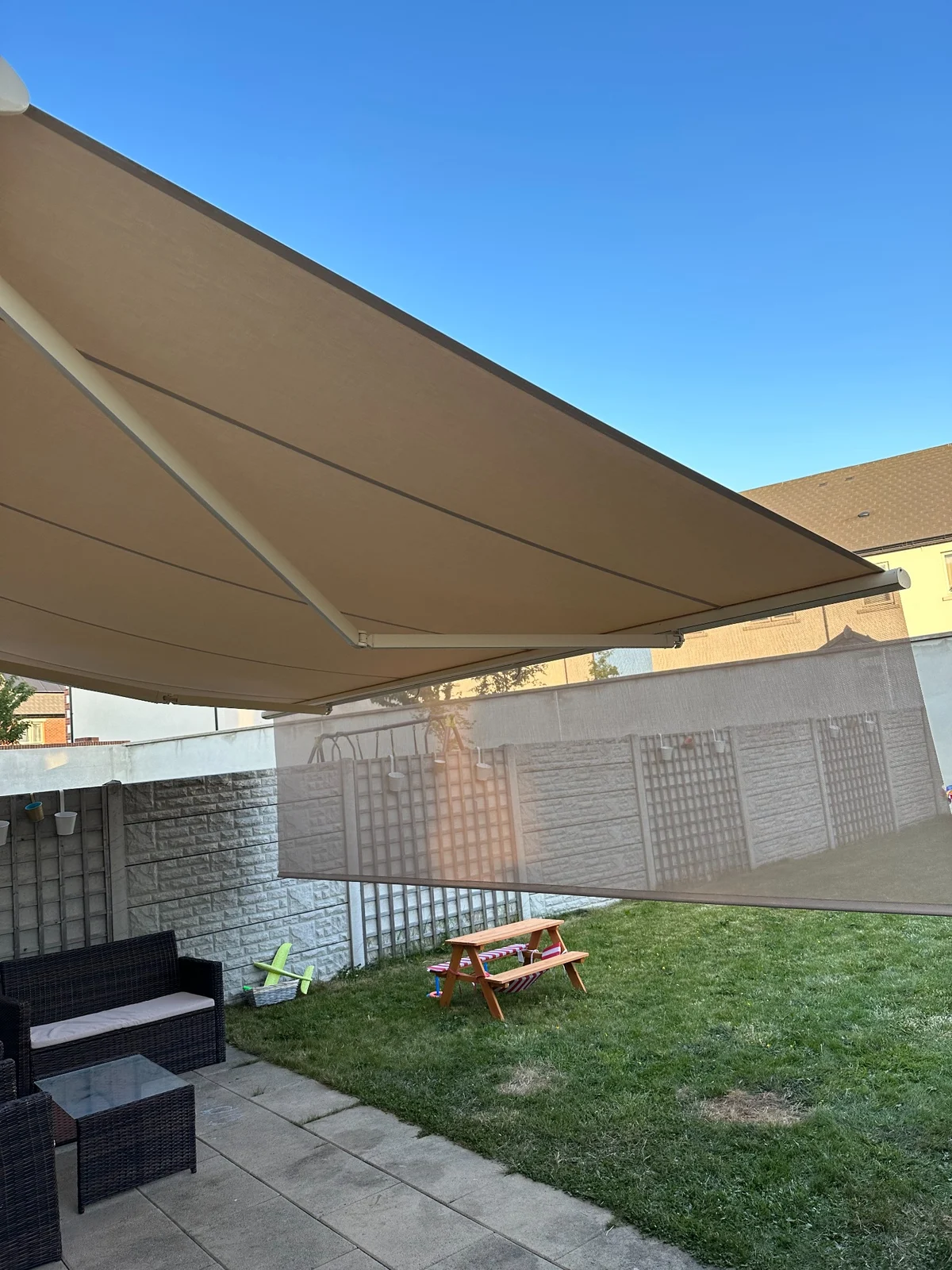 Close-up of the rounded front bar and rollable valance mechanism on a patio awning