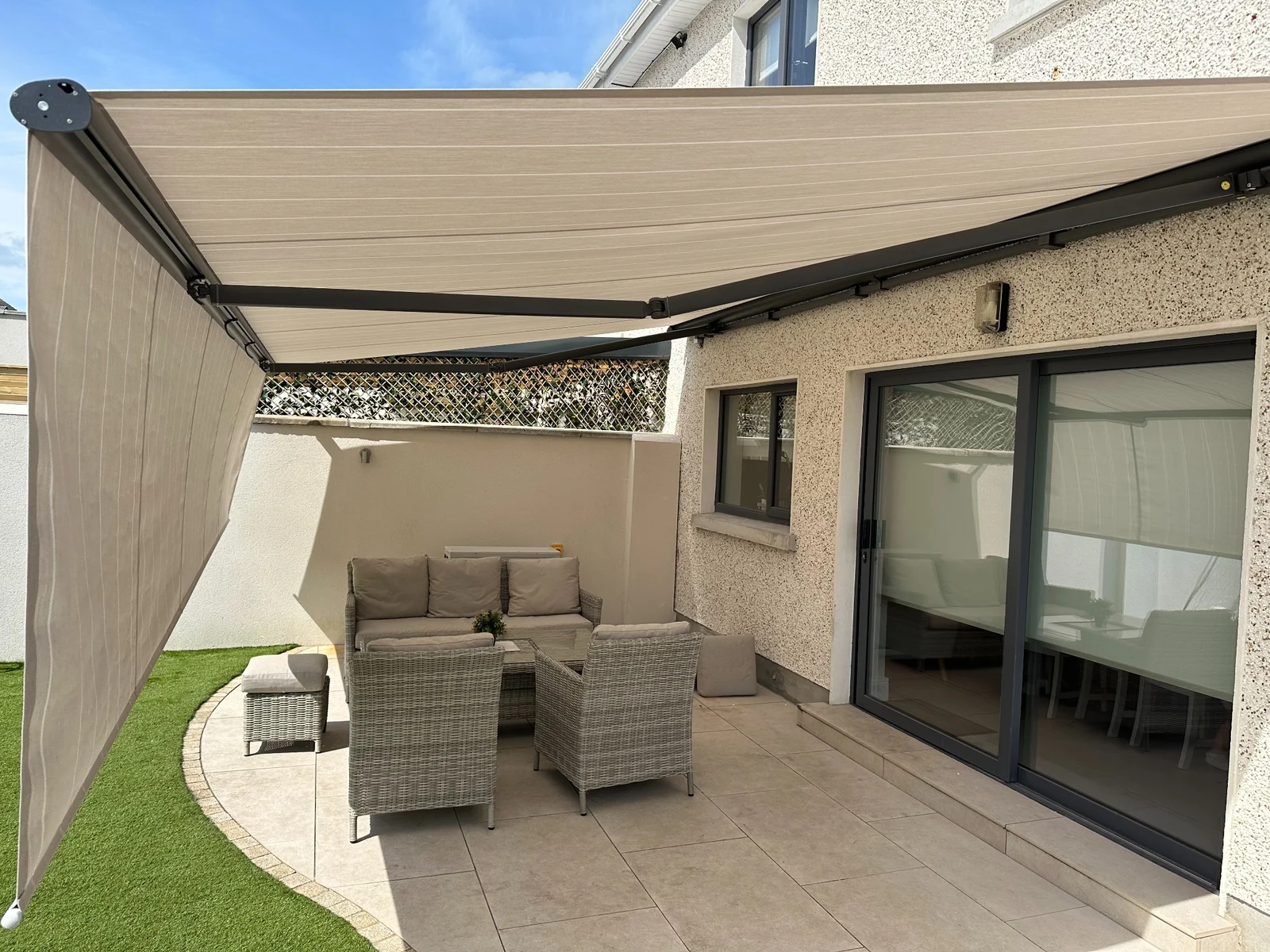 Large rollable front awning extended over outdoor seating with a lowered front screen