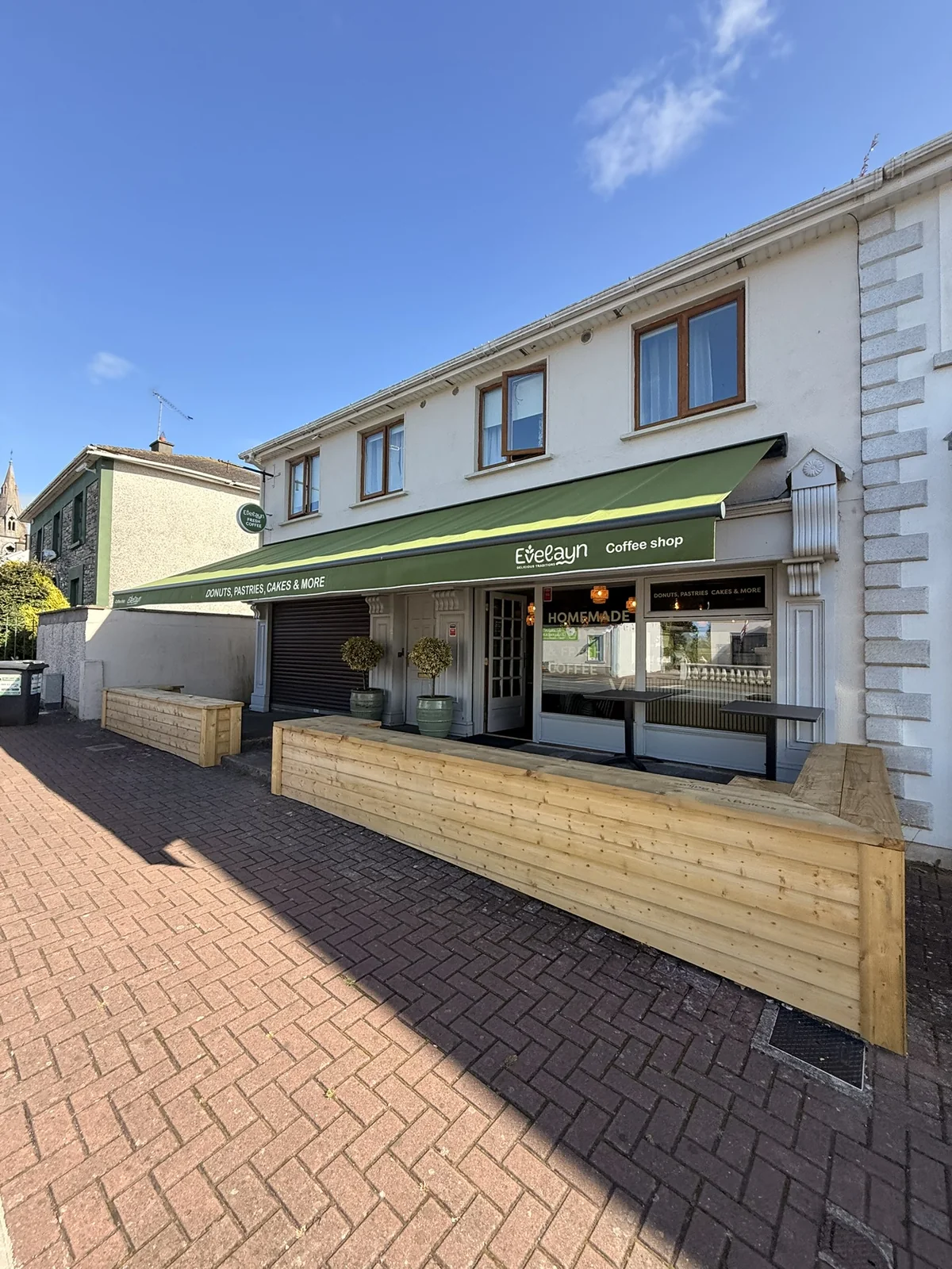 Green Eveeayn commercial awning across a coffee shop frontage