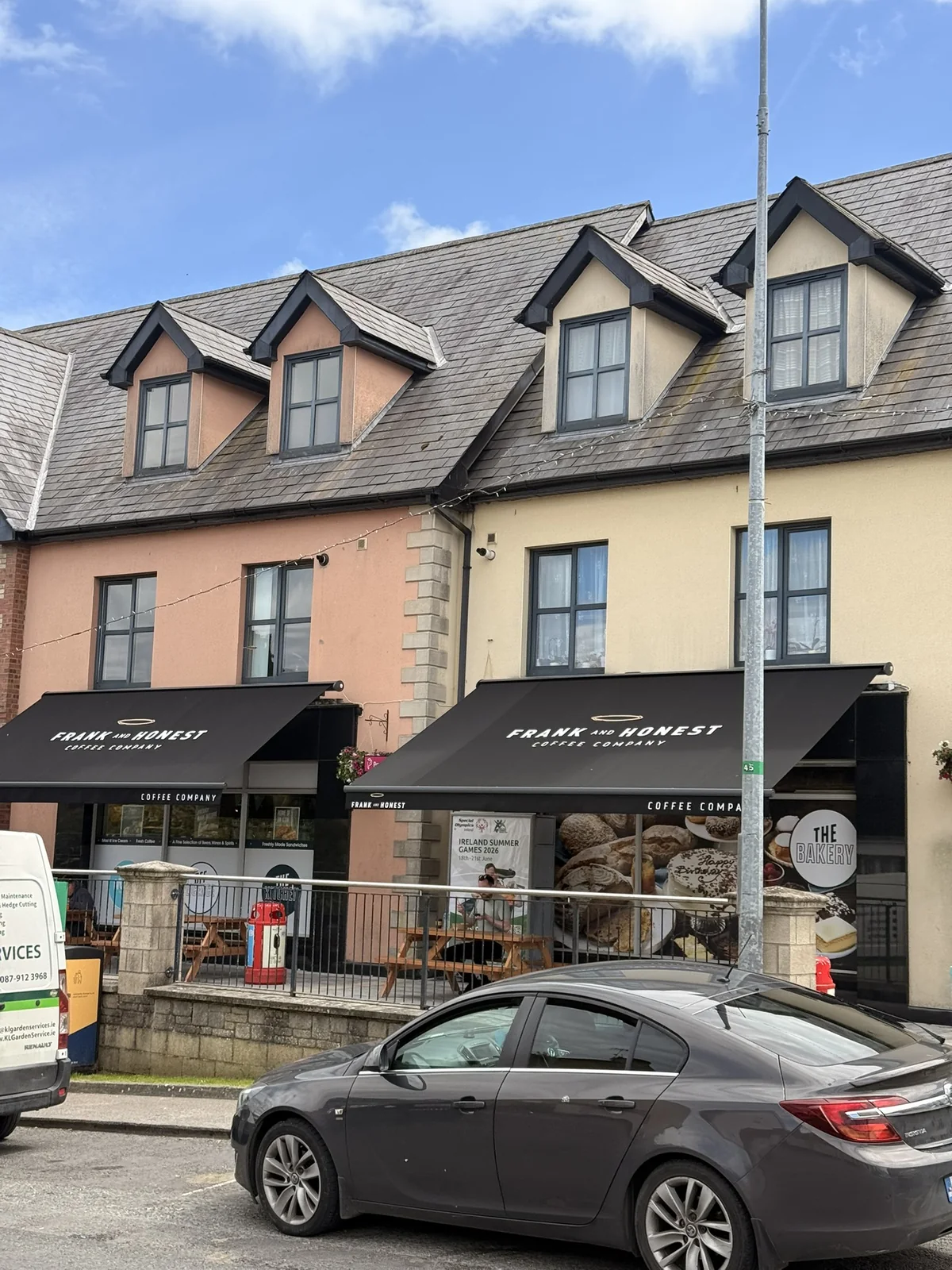Two black Frank and Honest branded awnings on a commercial frontage