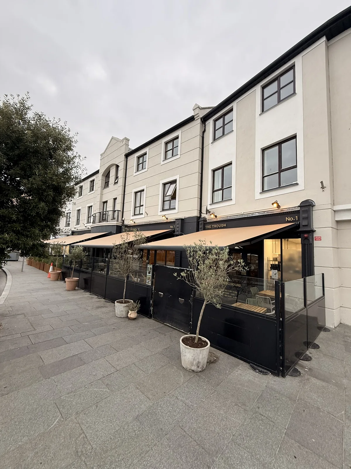 Taupe commercial awnings shading a restaurant terrace