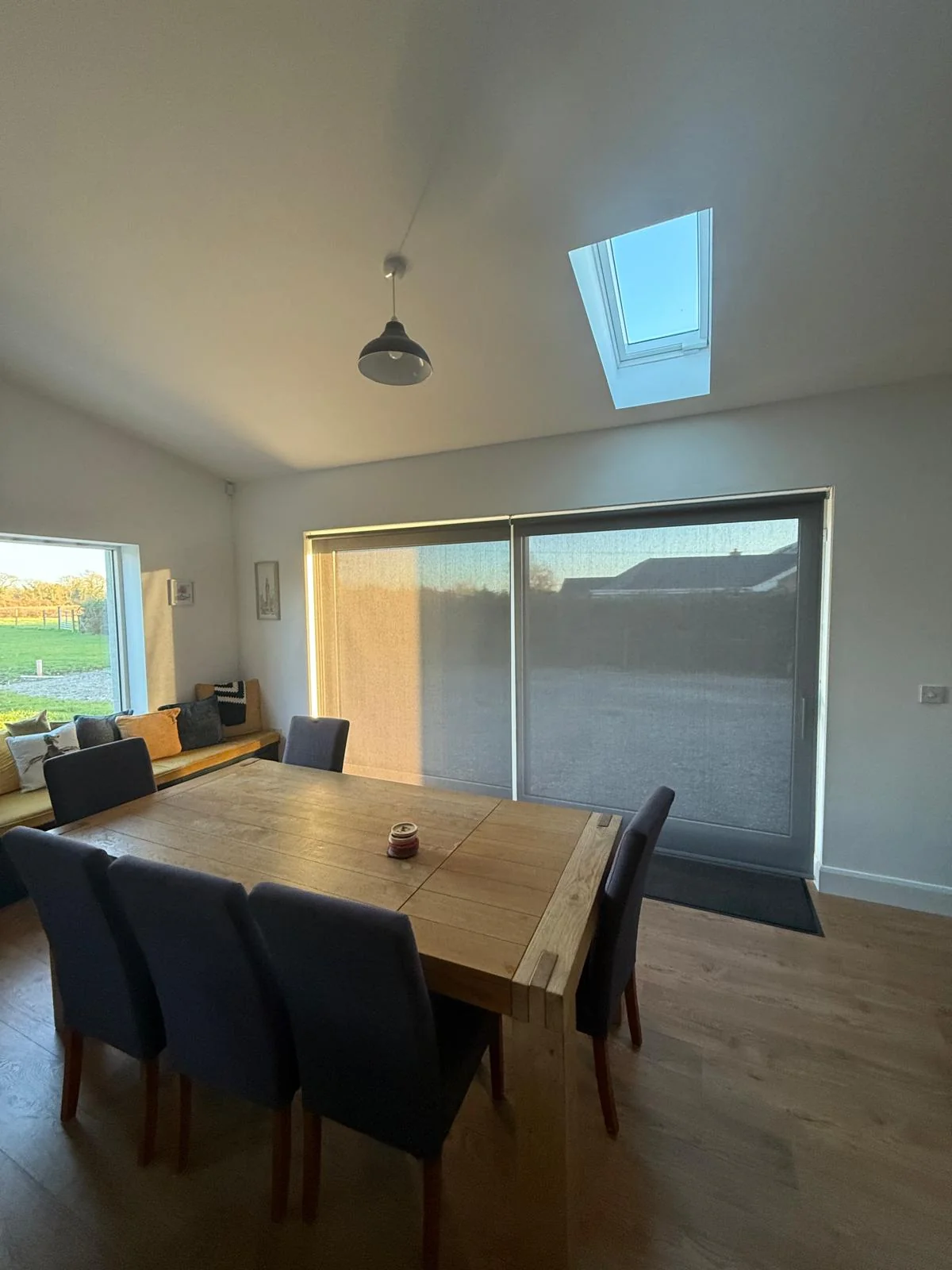 Motorised roller blinds providing evening privacy beside a dining area