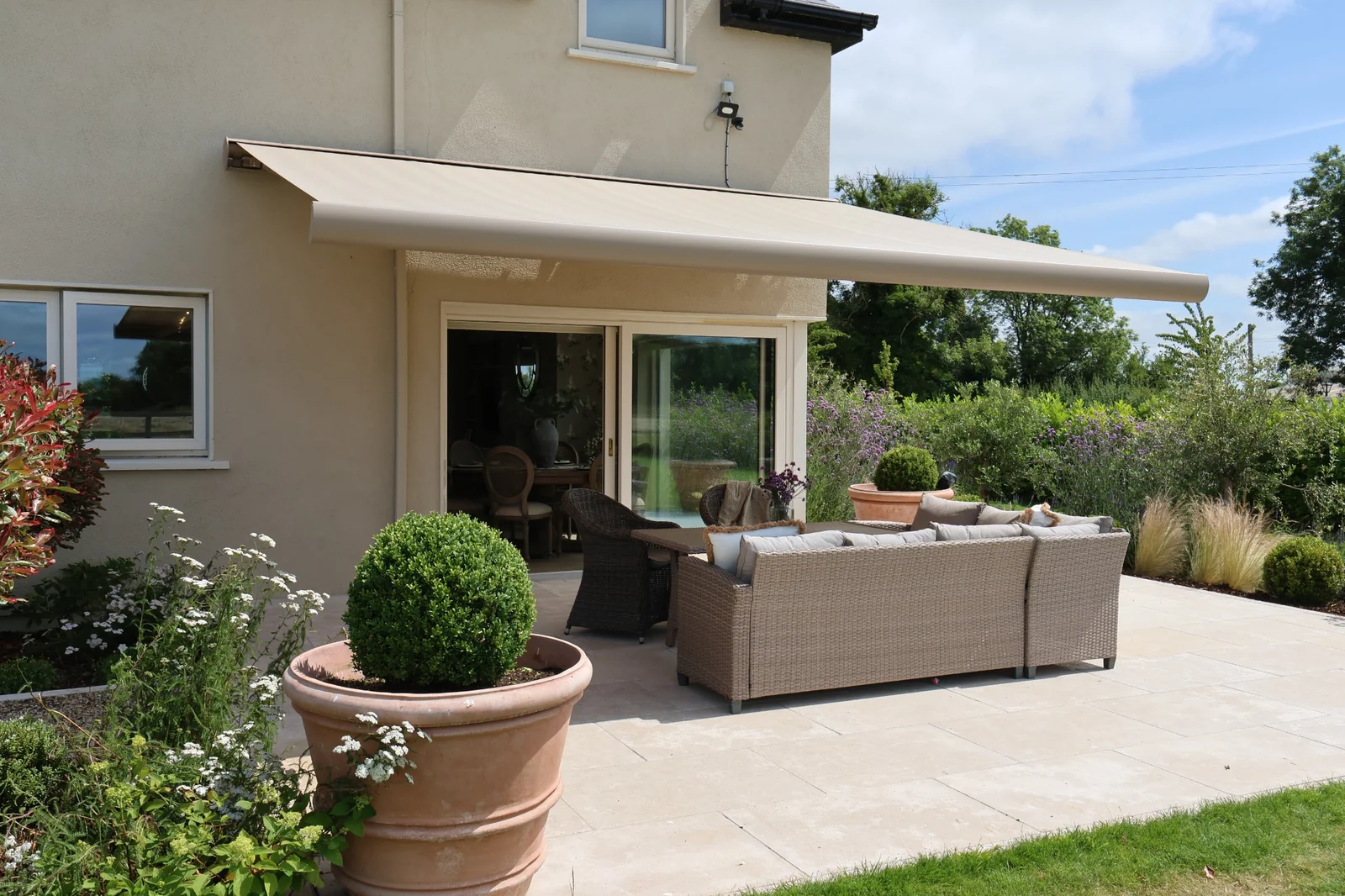 Retractable patio awning installed by AD Solutions beside a home in Ireland