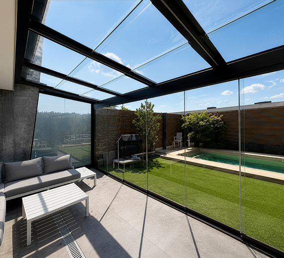 Interior view through a glazed pergola enclosure beside a pool terrace