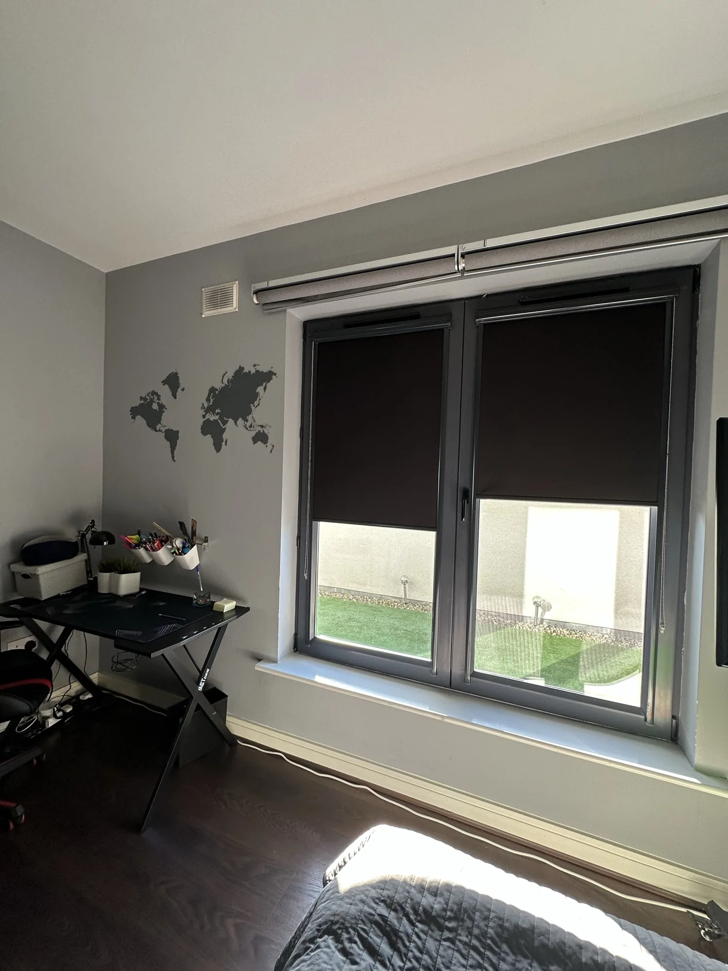 Dark blackout roller blinds fitted to a home office window