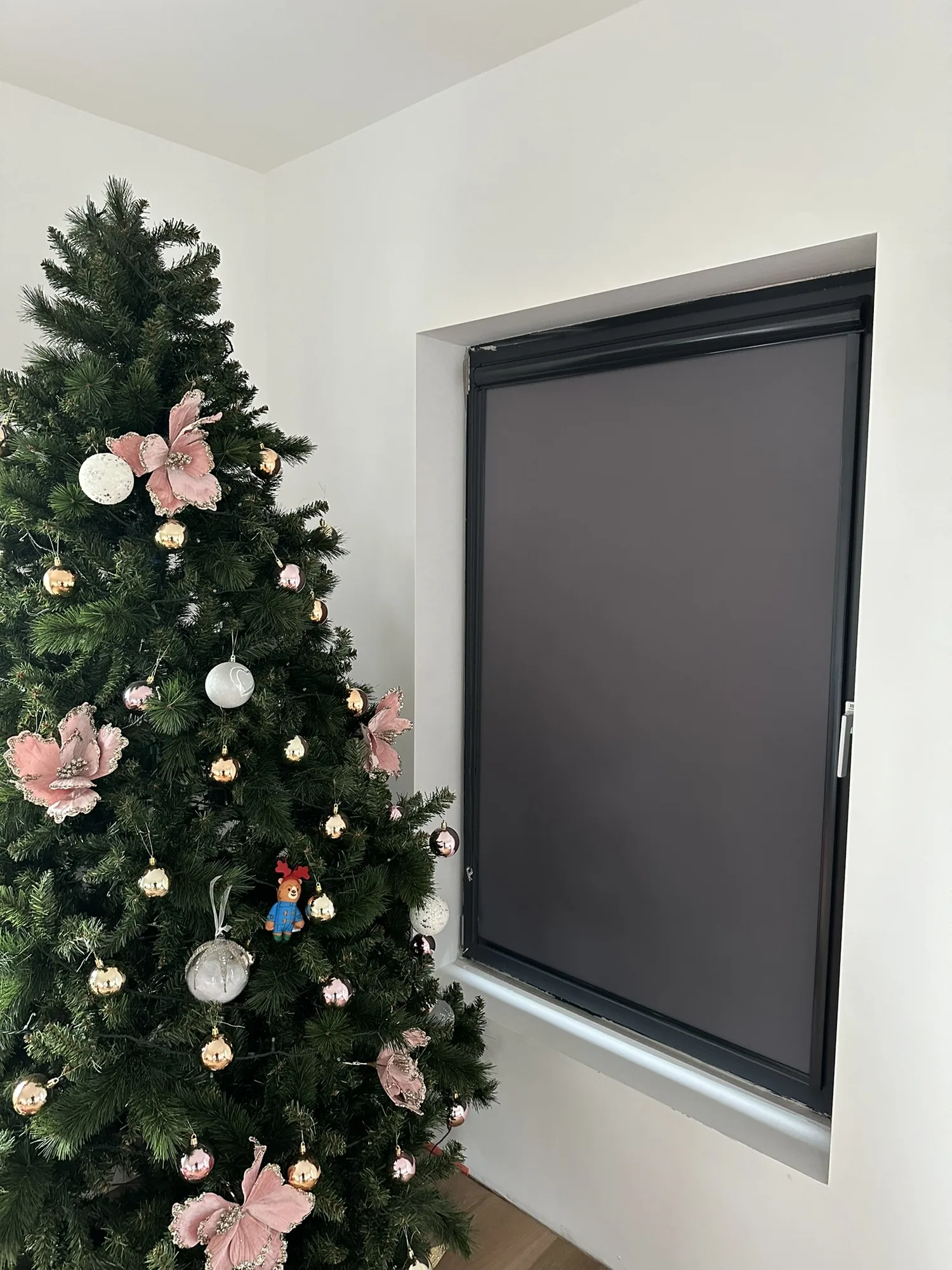 Dark grey roller blind installed beside a Christmas tree in an Irish home