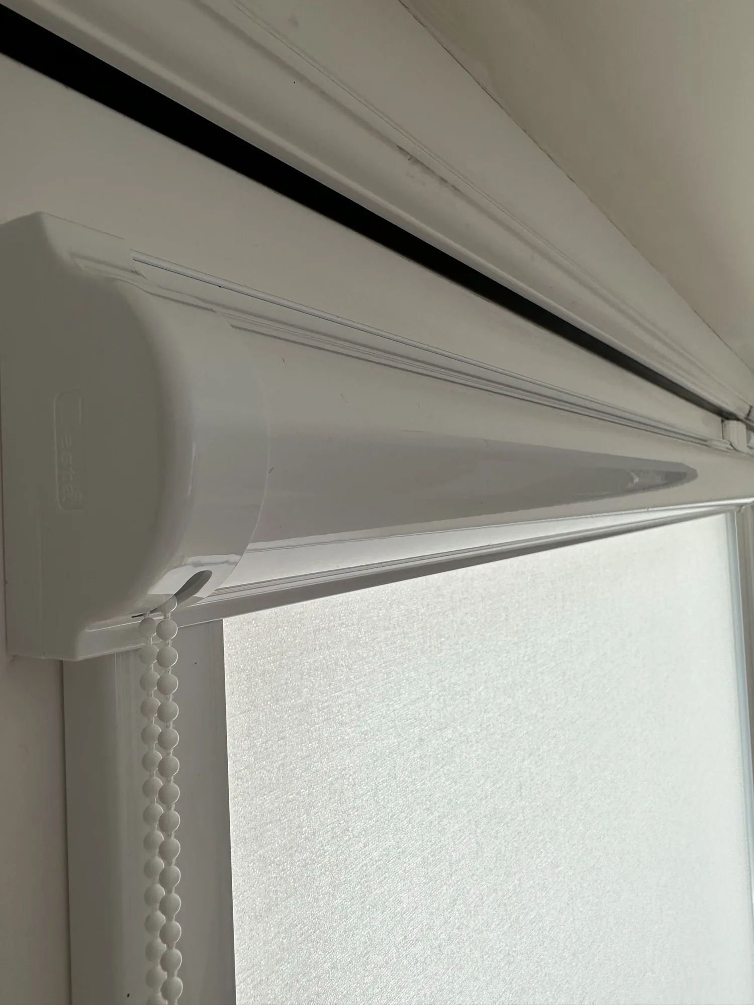 White roller blind cassette and chain mechanism close-up