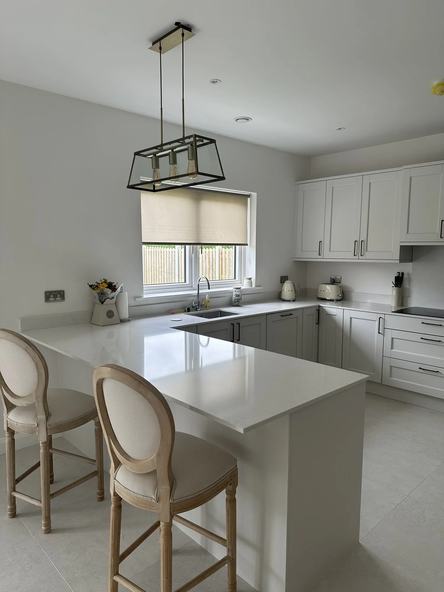 Roller blind controlling daylight above a modern kitchen sink
