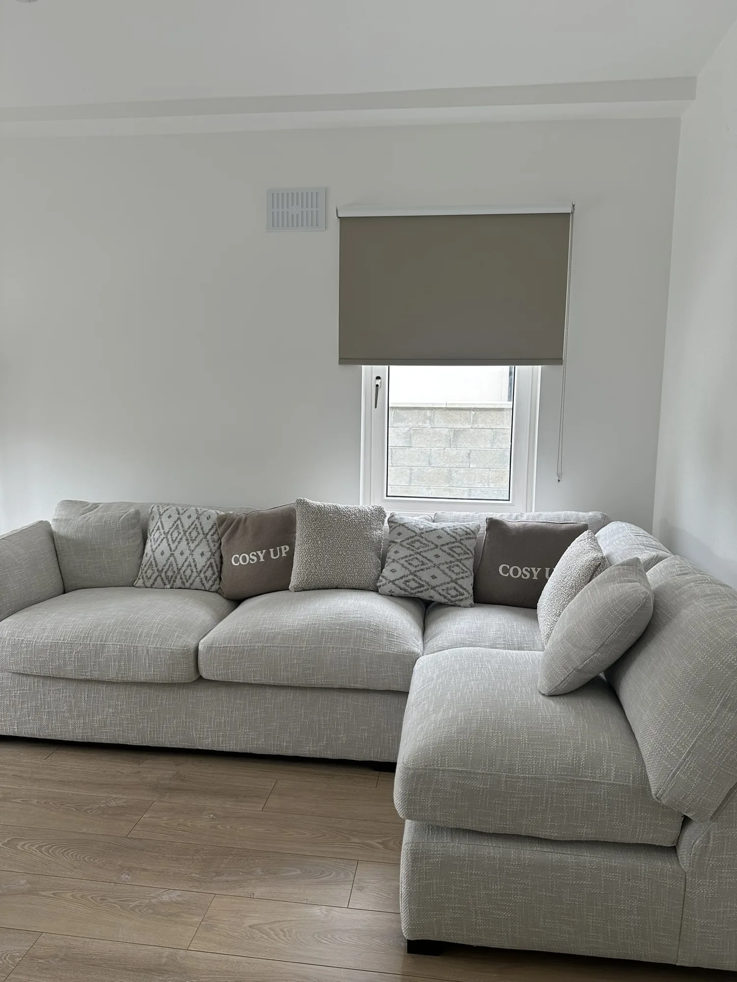 Taupe roller blind providing privacy in a neutral living room