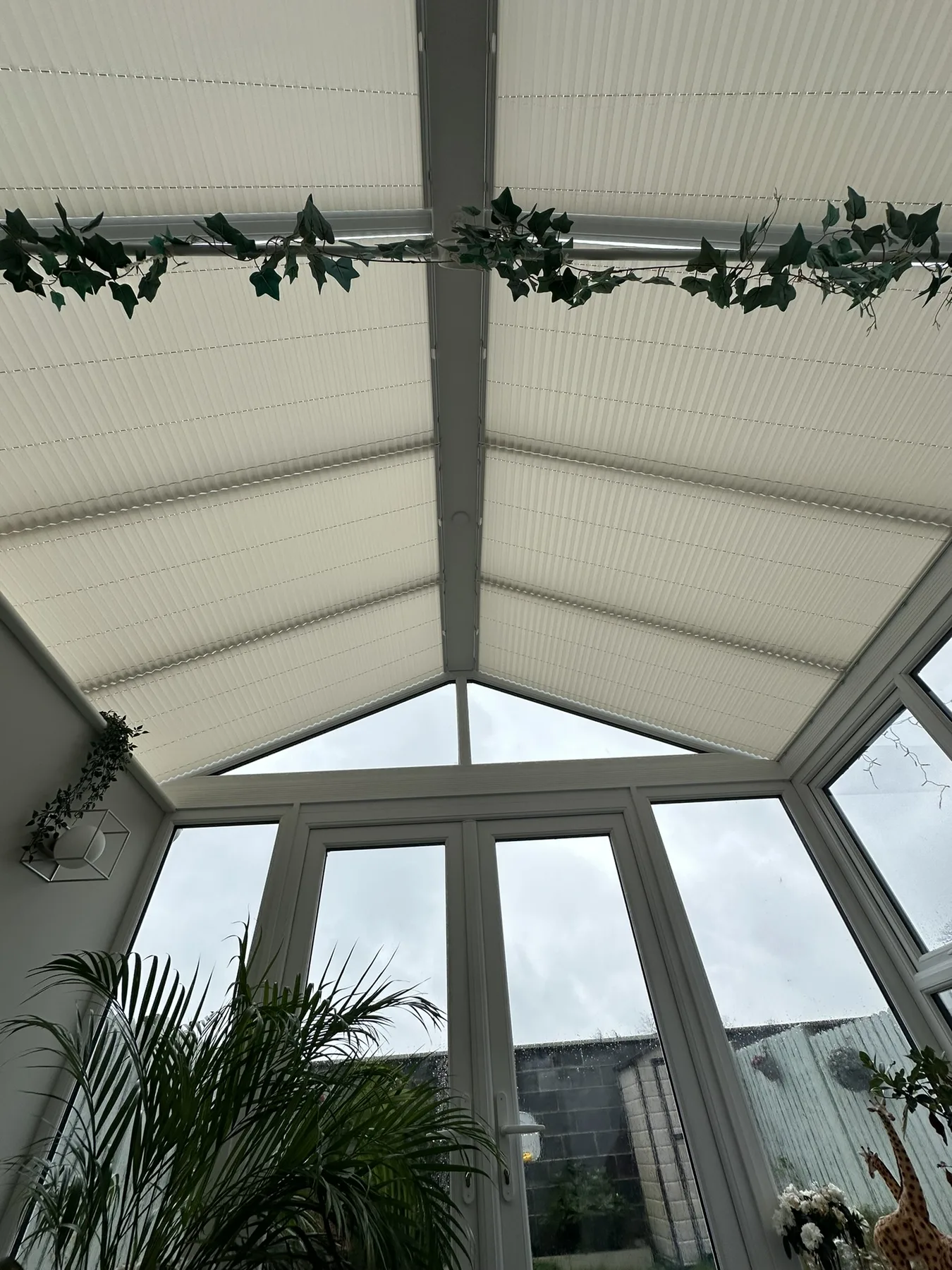 Pleated blinds covering multiple roof sections inside a conservatory