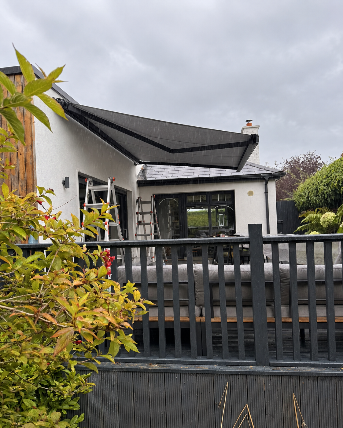 AD Solutions installers working on a SLIMLINE awning installation at a Dublin home during wet weather