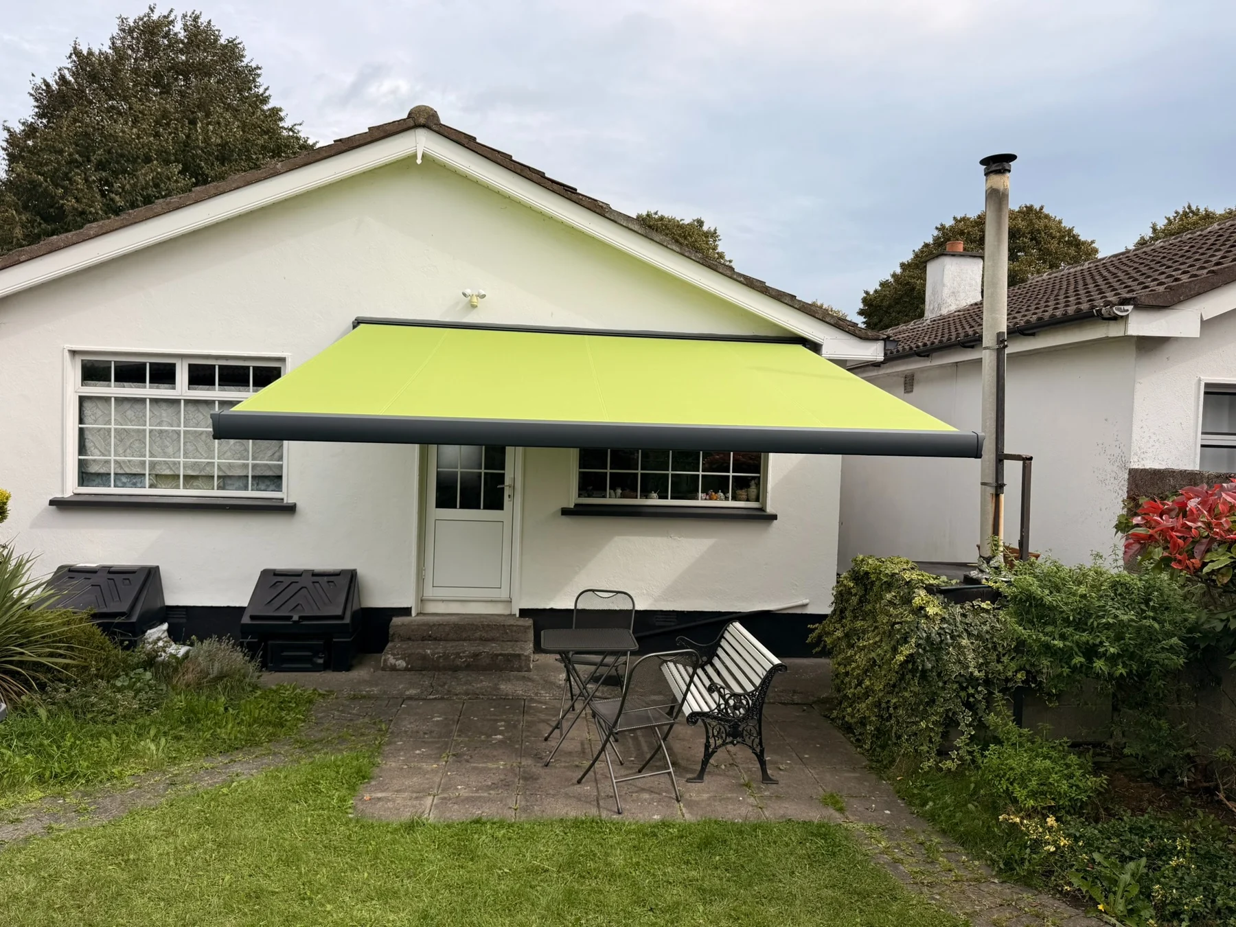 SLIMLINE full cassette awning with lime green fabric installed on a home in Kildare