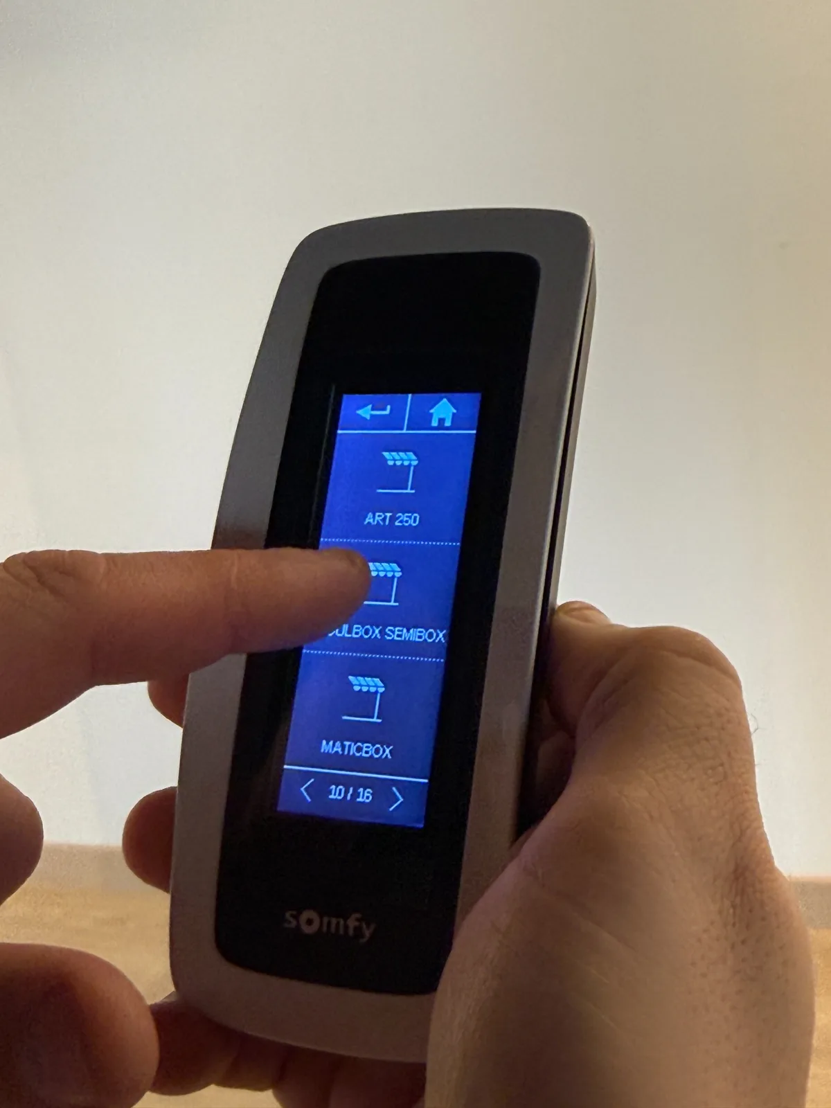 Close-up of a Somfy touchscreen remote used to select and control motorised shading