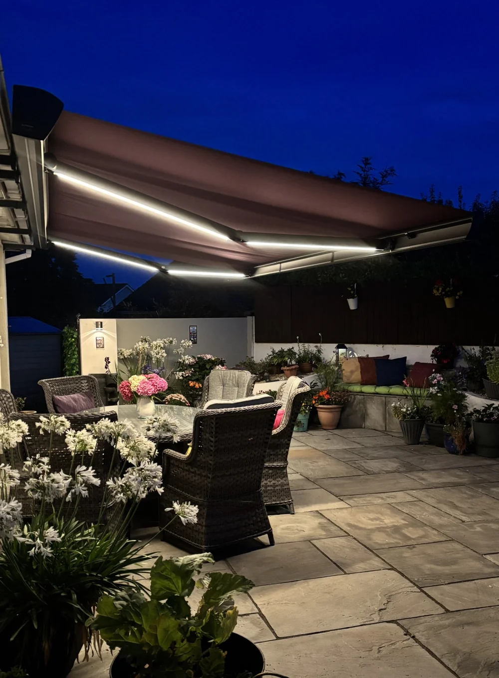 ULTRA awning with integrated LED lighting over a patio at dusk