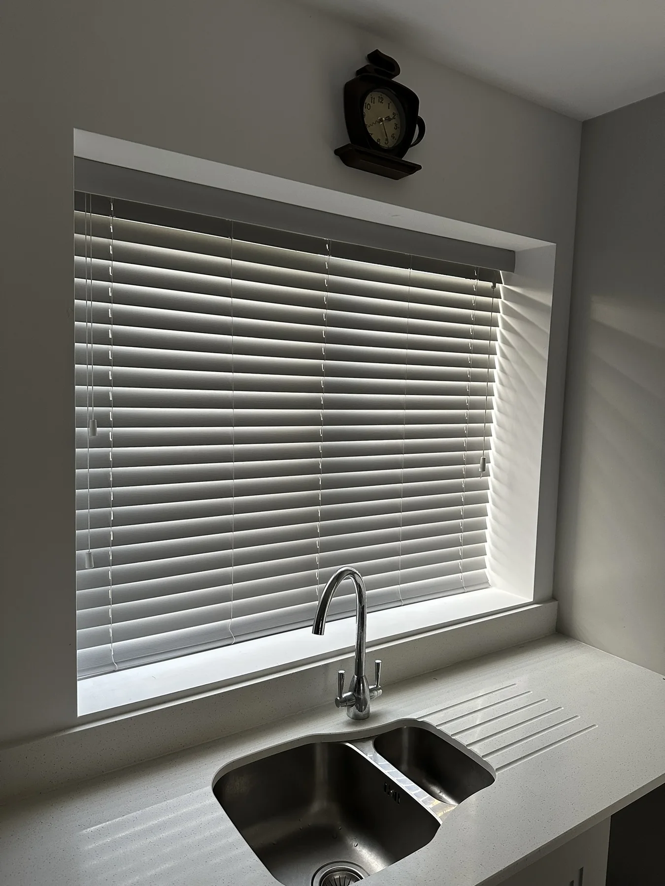 Grey Venetian blinds above a kitchen sink