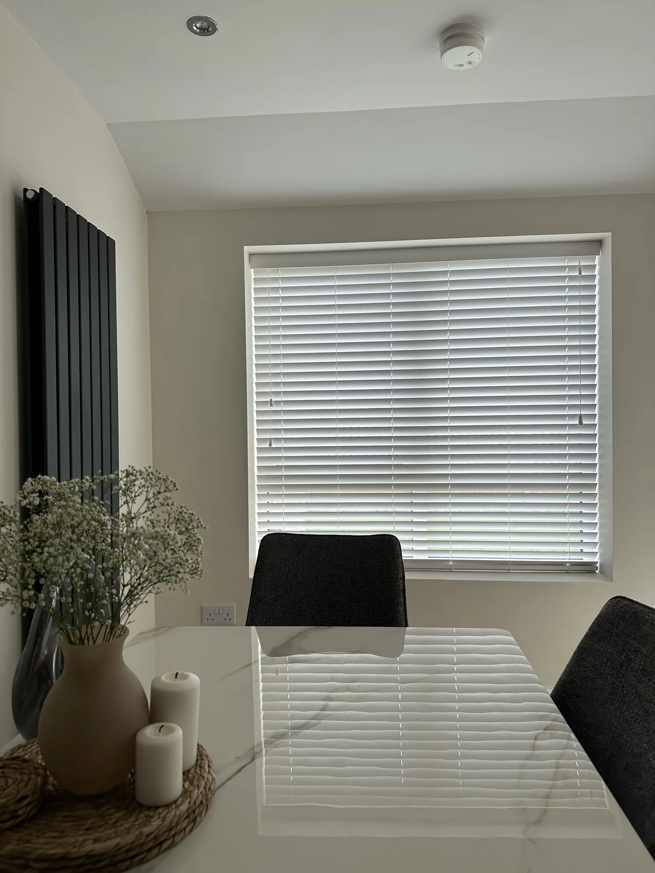 White Venetian blinds fitted to two dining room windows