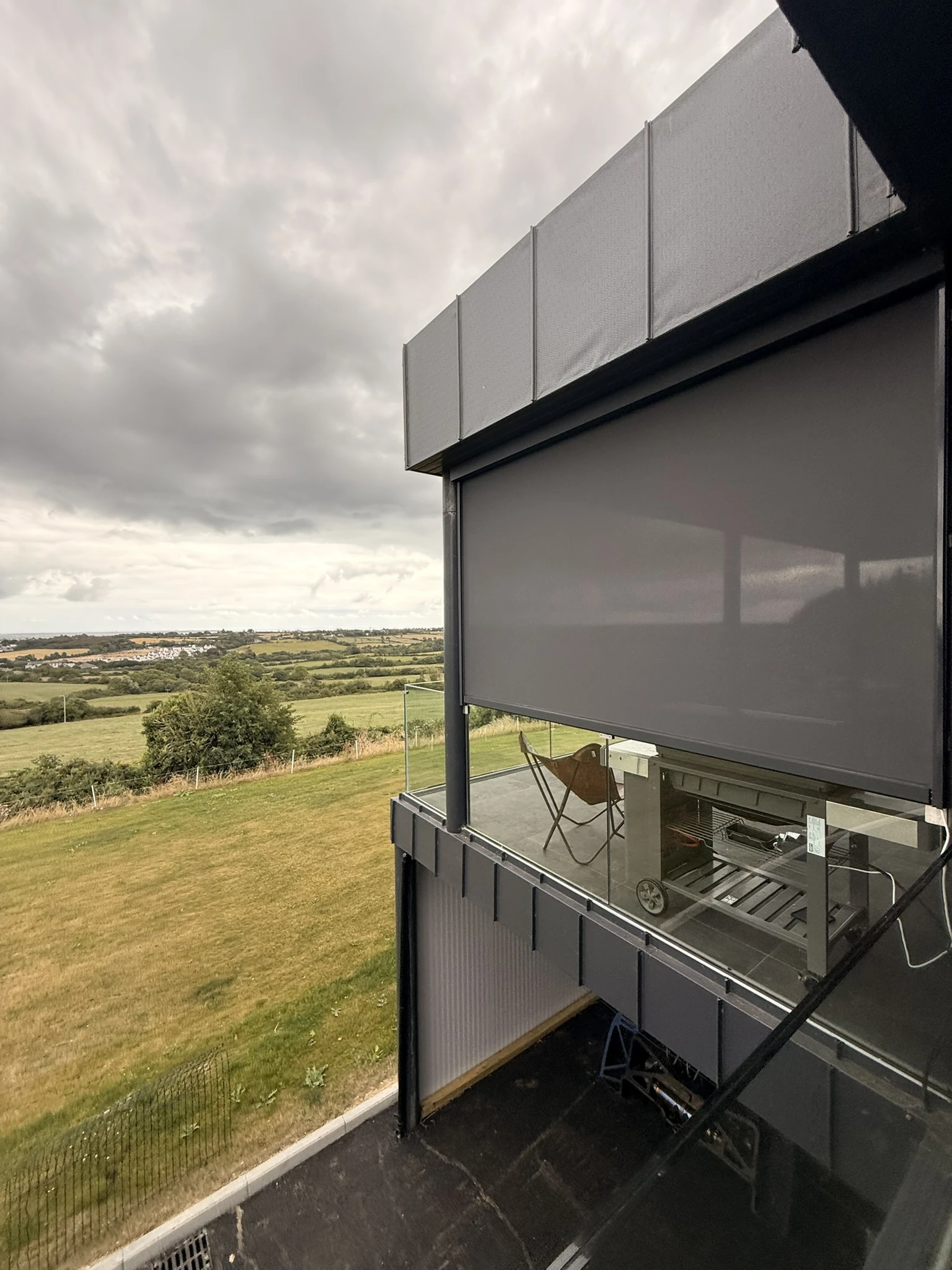 Motorised dark ZIP screen installed on an elevated balcony terrace in Ireland